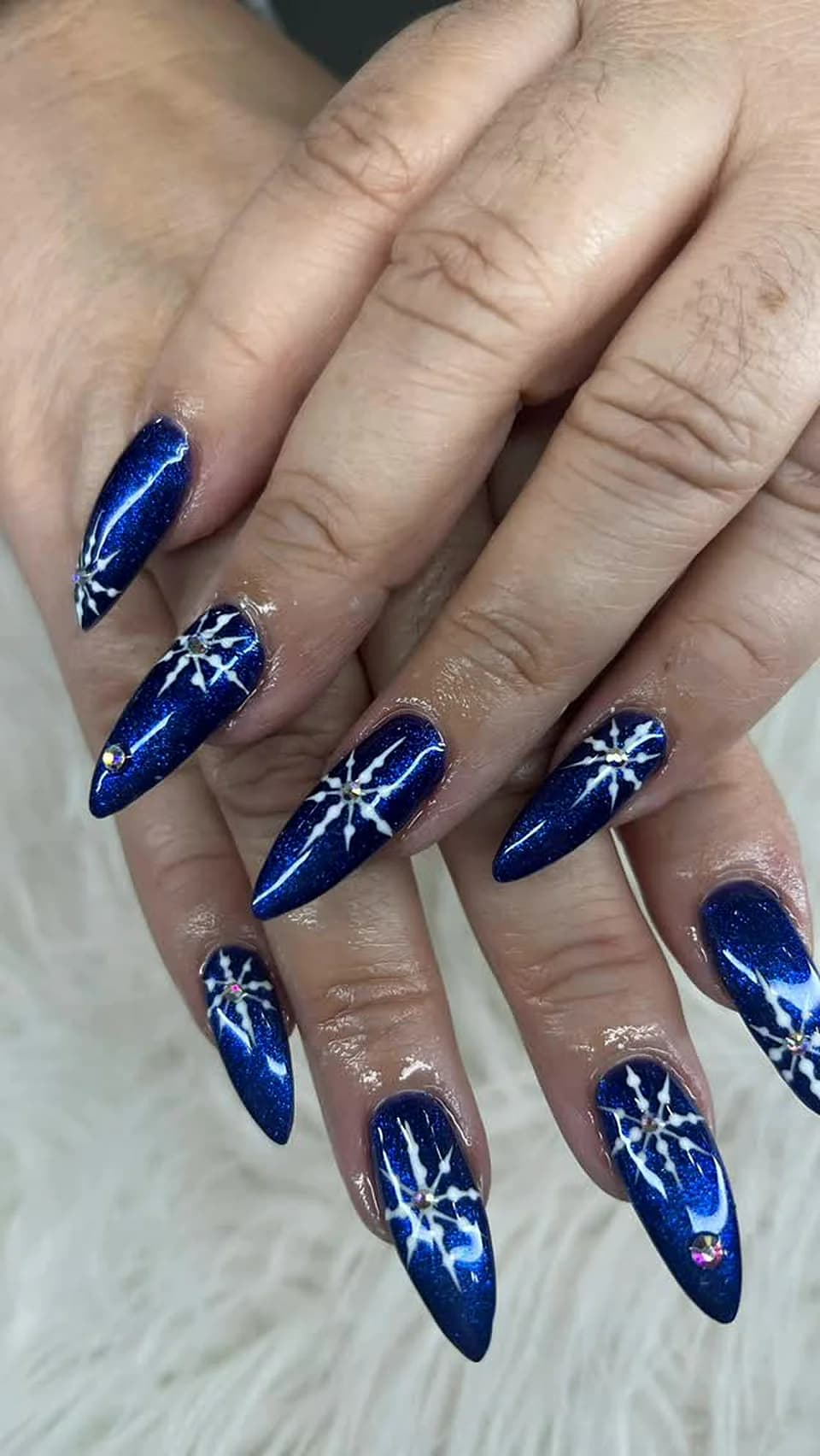 Navy blue nails with white snowflake and firework art done at Attraction Nails Salon in Roselle Park, NJ
