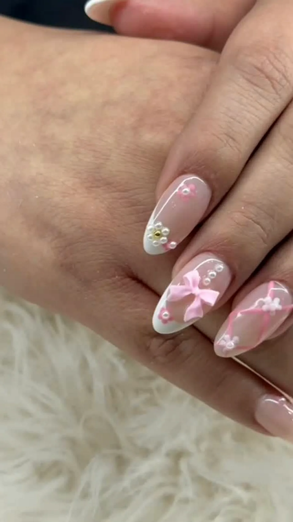 Nude nails with a 3D bow and pearl detailing done at Attraction Nails Salon in Roselle Park, NJ