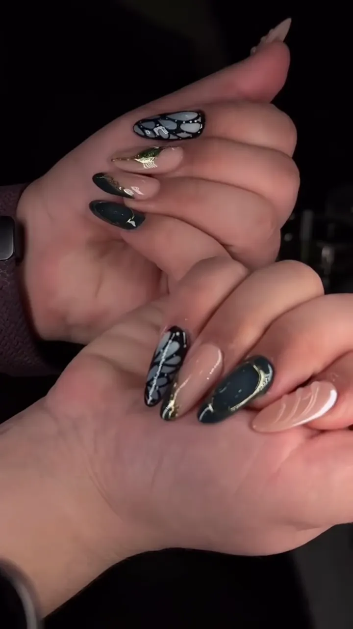 Video of black and gold nails with butterfly art