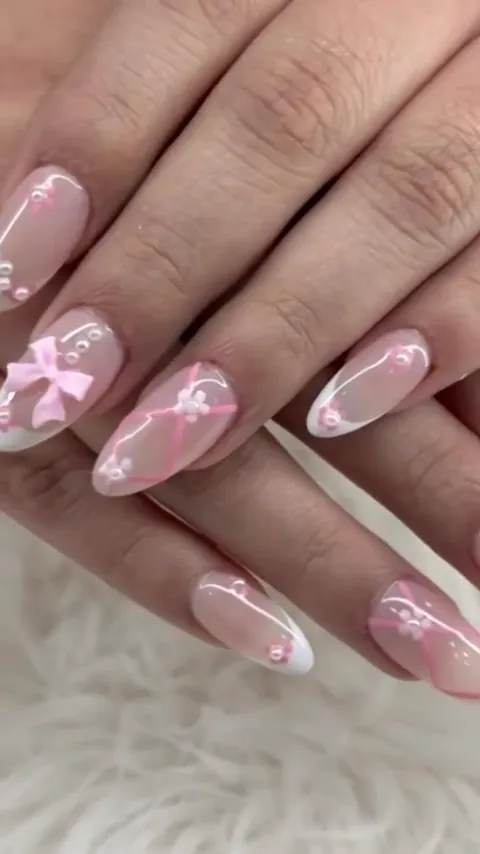 Video of pink nails with a 3D bow and pearls