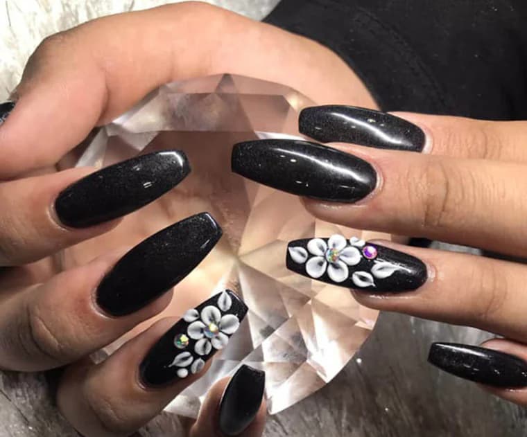 Black gel manicure with a hand-sculpted white flower, Attraction Nails Salon